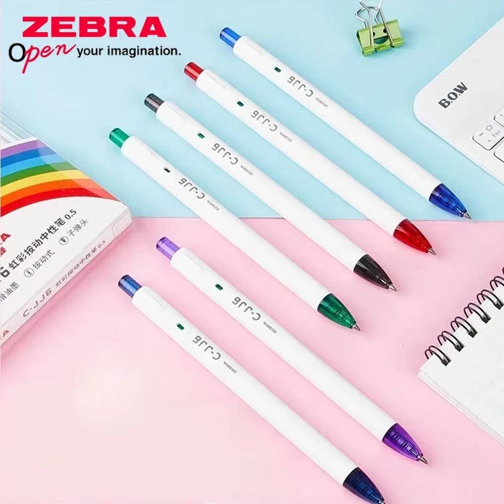 Zebra pens with colored tips on a pink and blue background, featuring Zebra branding.